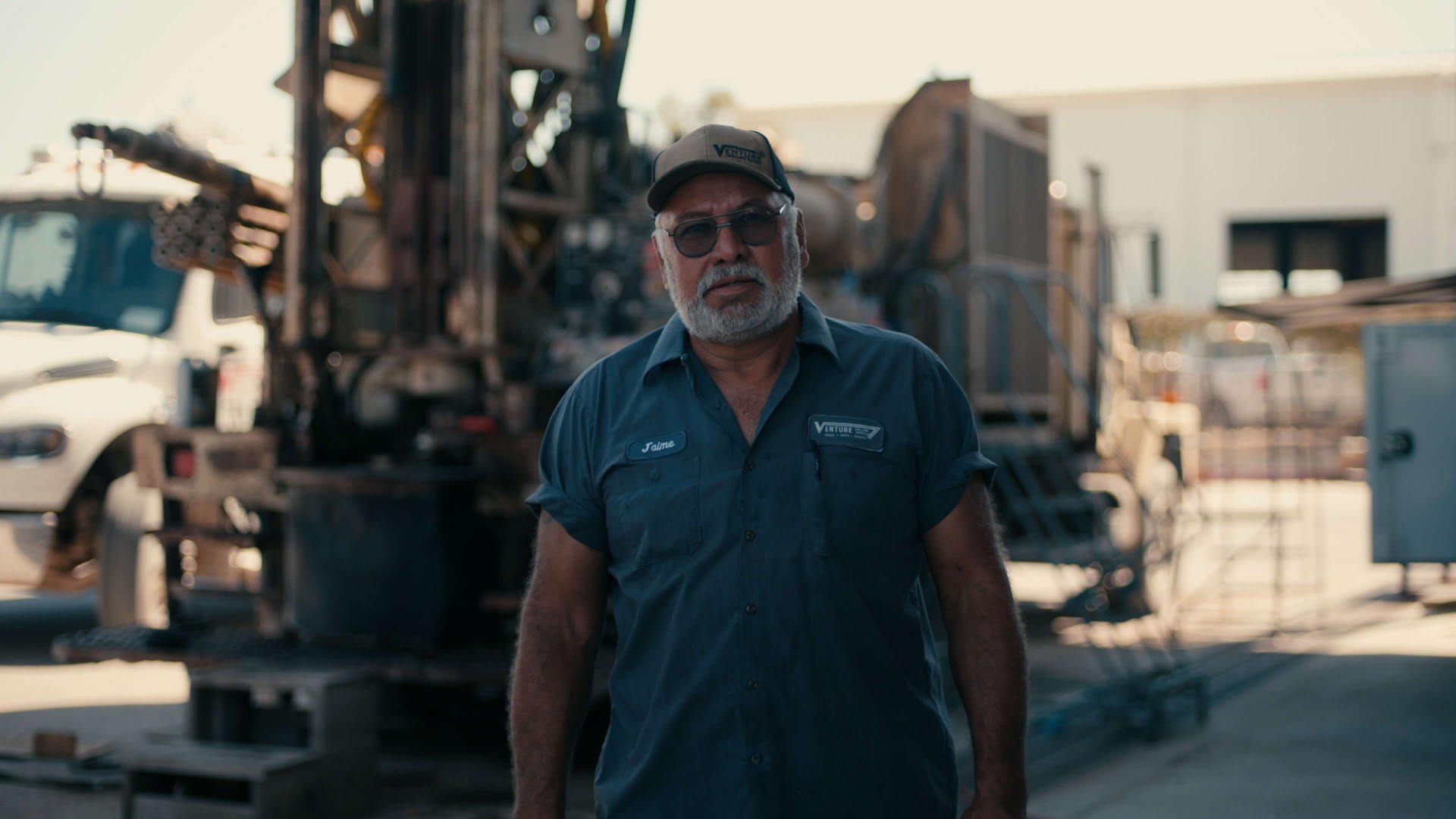 Operator's hand on rig controls at dusk